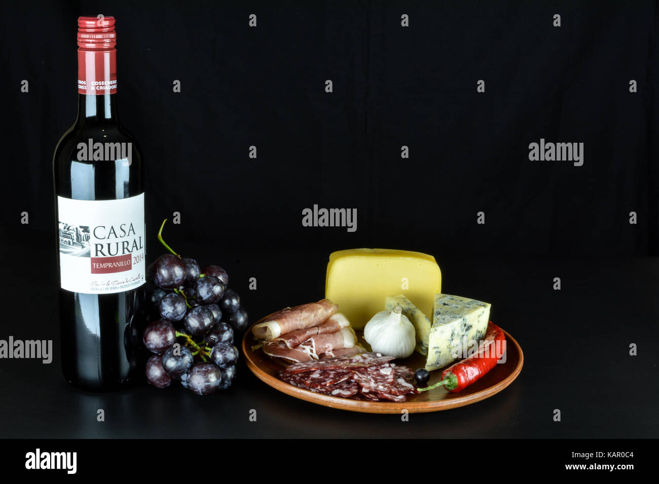 Primorskoe, Ukraine - 4 août 2016 : vin rouge espagnol de 2014 'casa rural' tempranillo' , un tas de raisins rouges, fromage bleu, proshto, de salami, de l'ail Banque D'Images