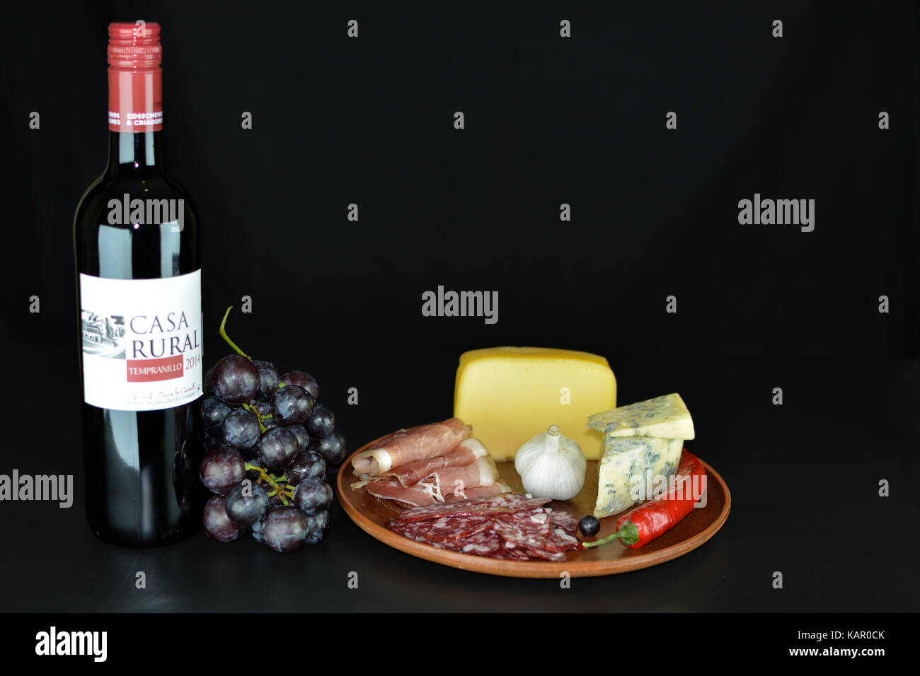 Primorskoe, Ukraine - 4 août 2016 : vin rouge espagnol de 2014 'casa rural' tempranillo' , un tas de raisins rouges, fromage bleu, proshto, de salami, de l'ail Banque D'Images