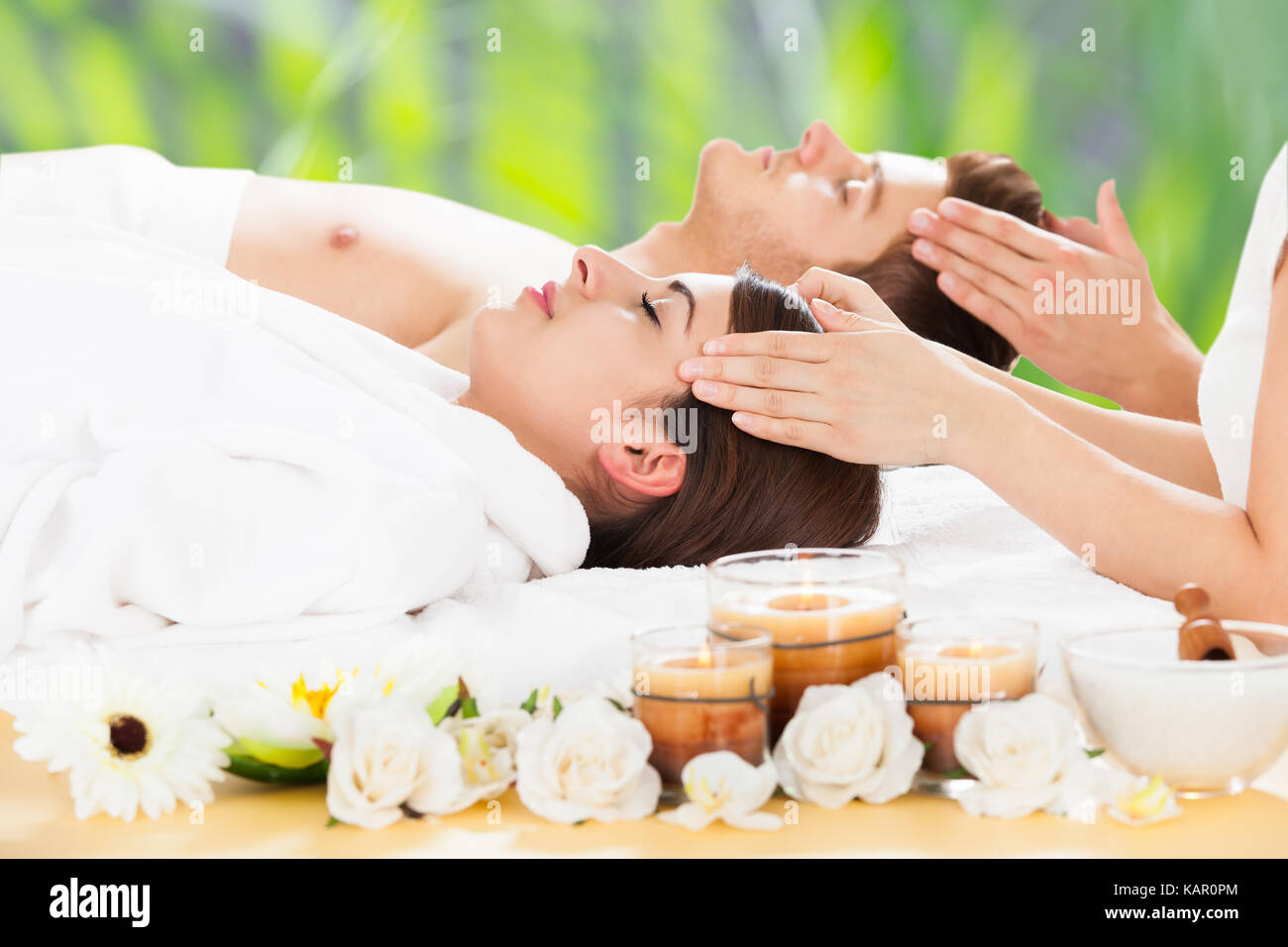 Vue latérale d'ambiance jeune couple recevant head massage beauty spa Banque D'Images