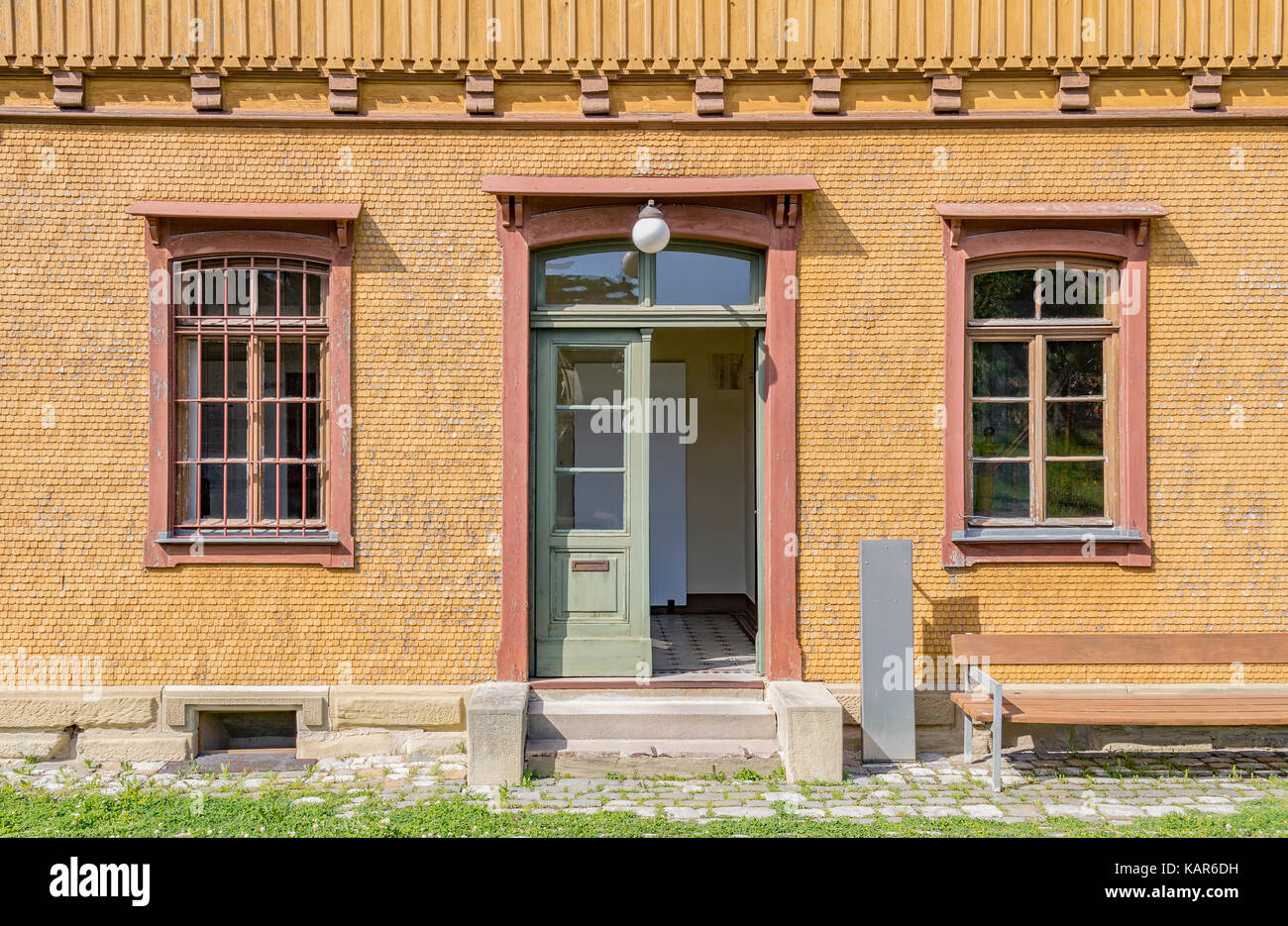 Lambris de bois historique façade de maison avec des barreaux aux fenêtres  dans l'ambiance ensoleillée Photo Stock - Alamy