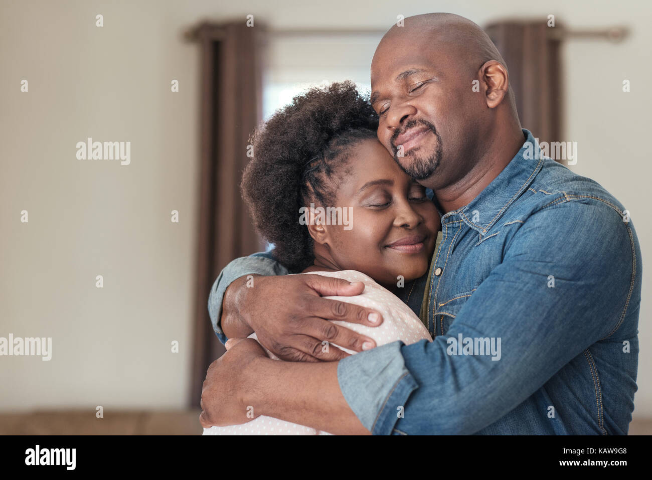 L'Afrique de l'affectueux couple standing at home se tenant Banque D'Images