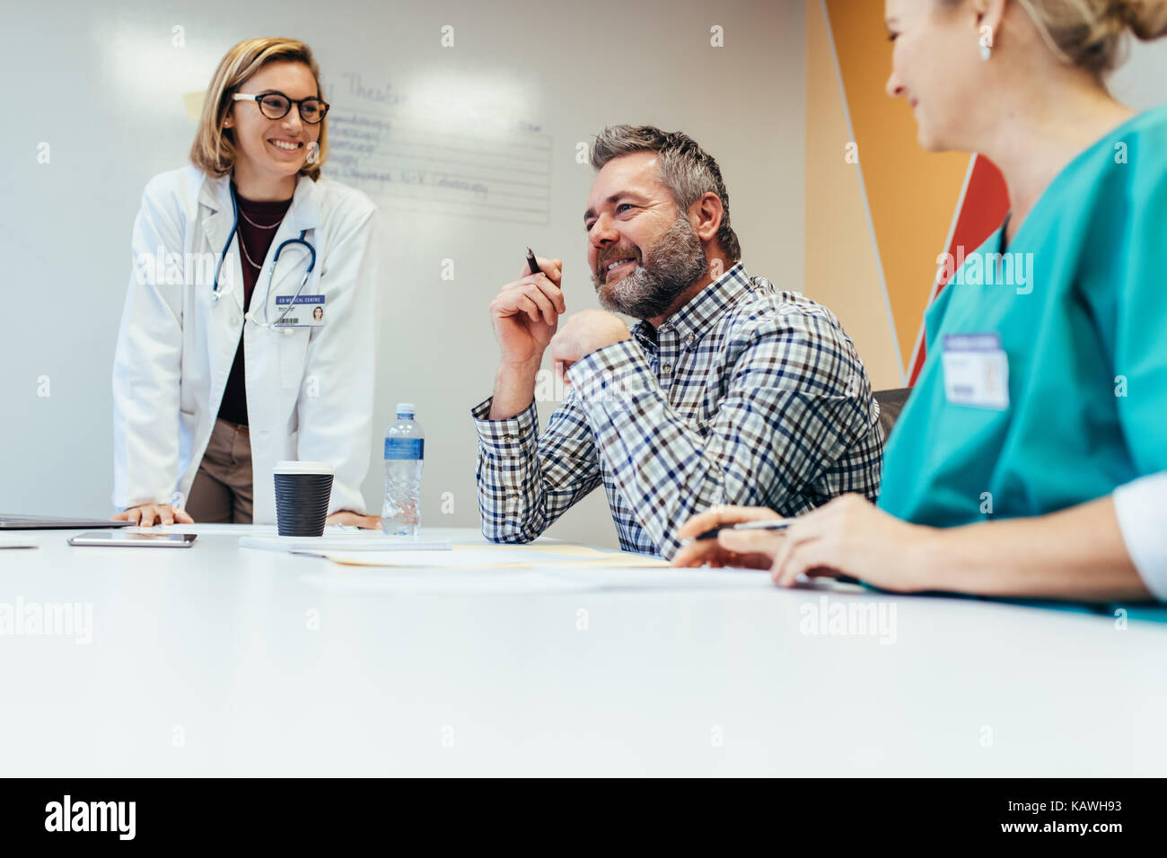 L'équipe médicale de l'interaction positive lors d'une réunion dans la salle de l'hôpital. Les travailleurs de la santé, hommes et femmes au cours d'une séance d'information médicale. Banque D'Images