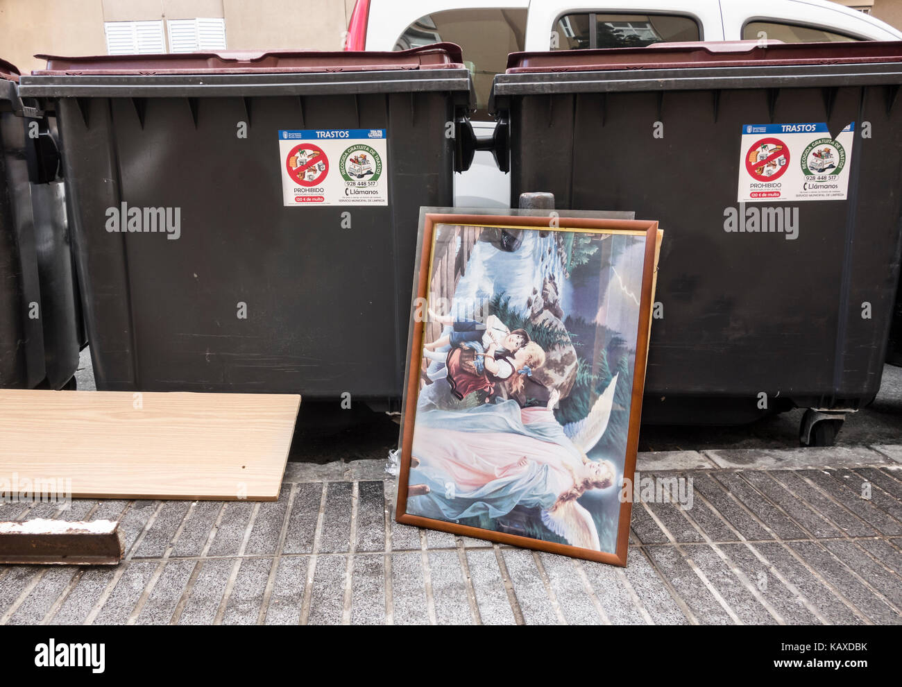 Peinture religieuse laissée sur le côté d'une poubelle dans la rue en Espagne Banque D'Images