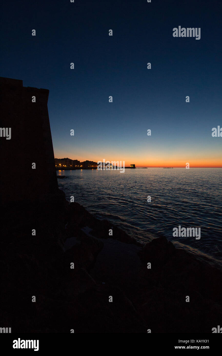 Coucher du soleil sur la mer de la côte sicilienne de Trapani avec 'Tour de Ligny" (l'un des principaux symboles de la ville) à l'arrière-plan Banque D'Images