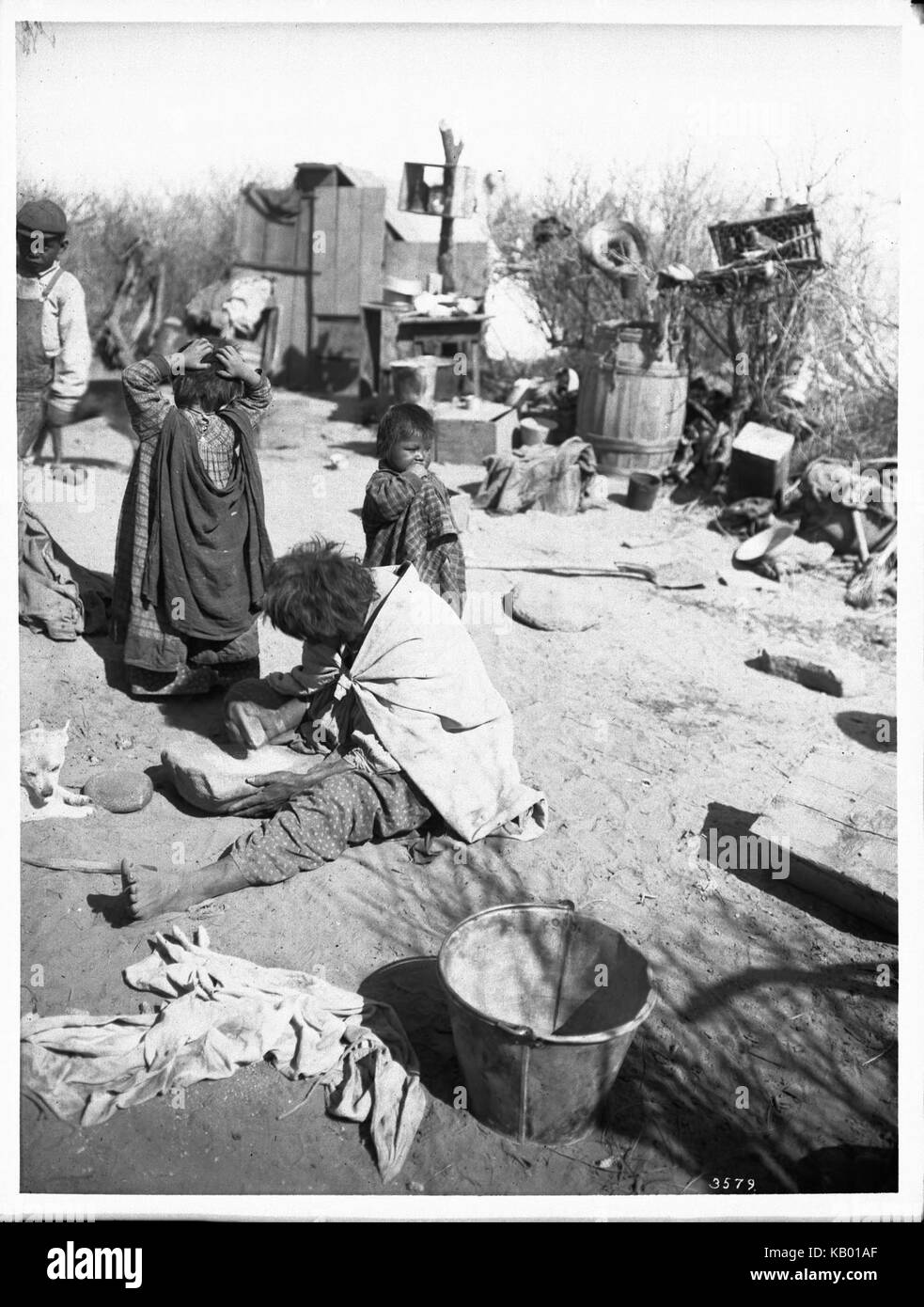 Le broyage du maïs sur une femme mortier de pierre dans un camp indien Apache, Palomas, Apache Indian Reservation, 1903 (3579) du SHC Banque D'Images