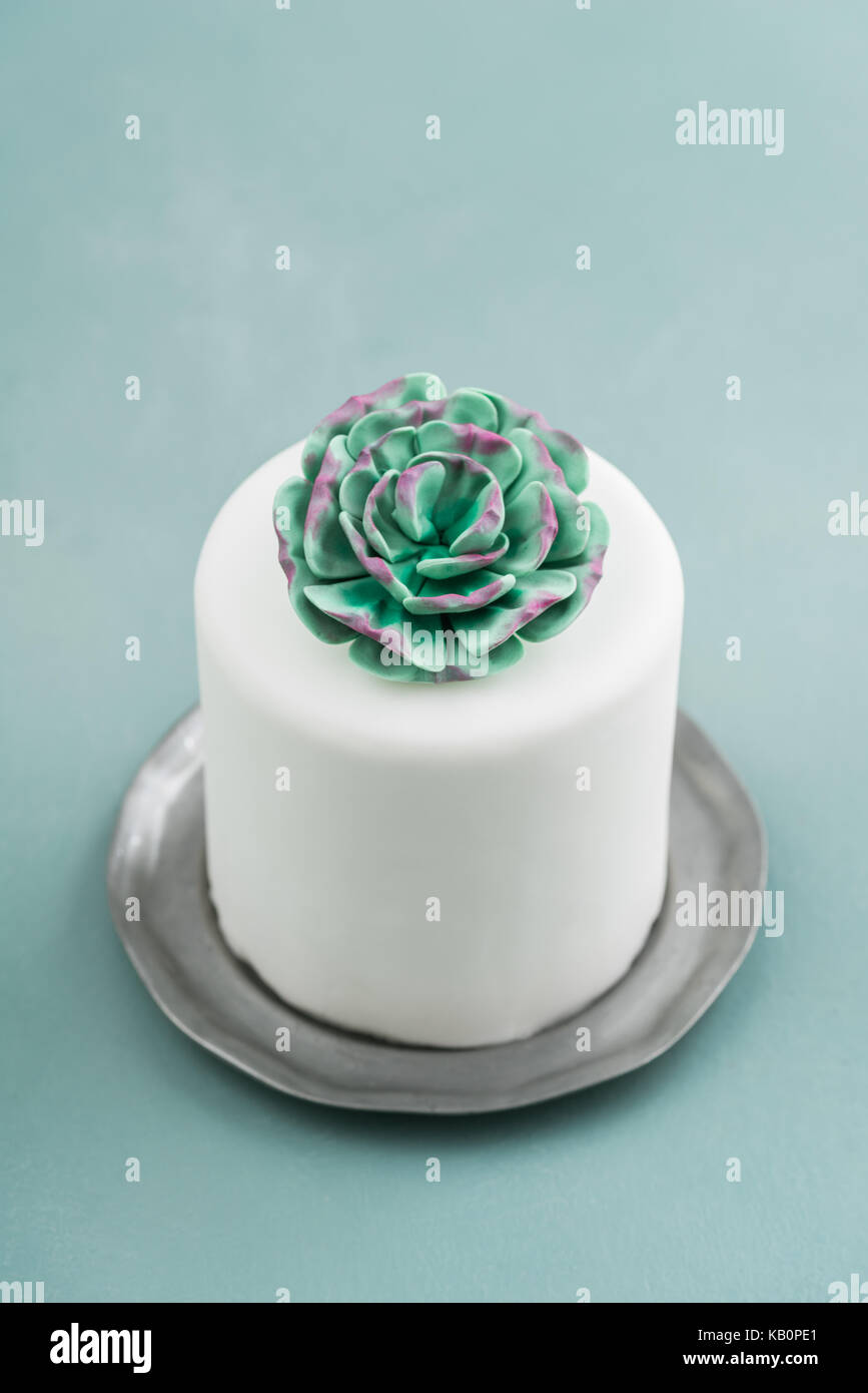 Mini gâteau de mariage blanc couvert de la pâte à sucre fondant sur une plaque d'étain succulentes Banque D'Images