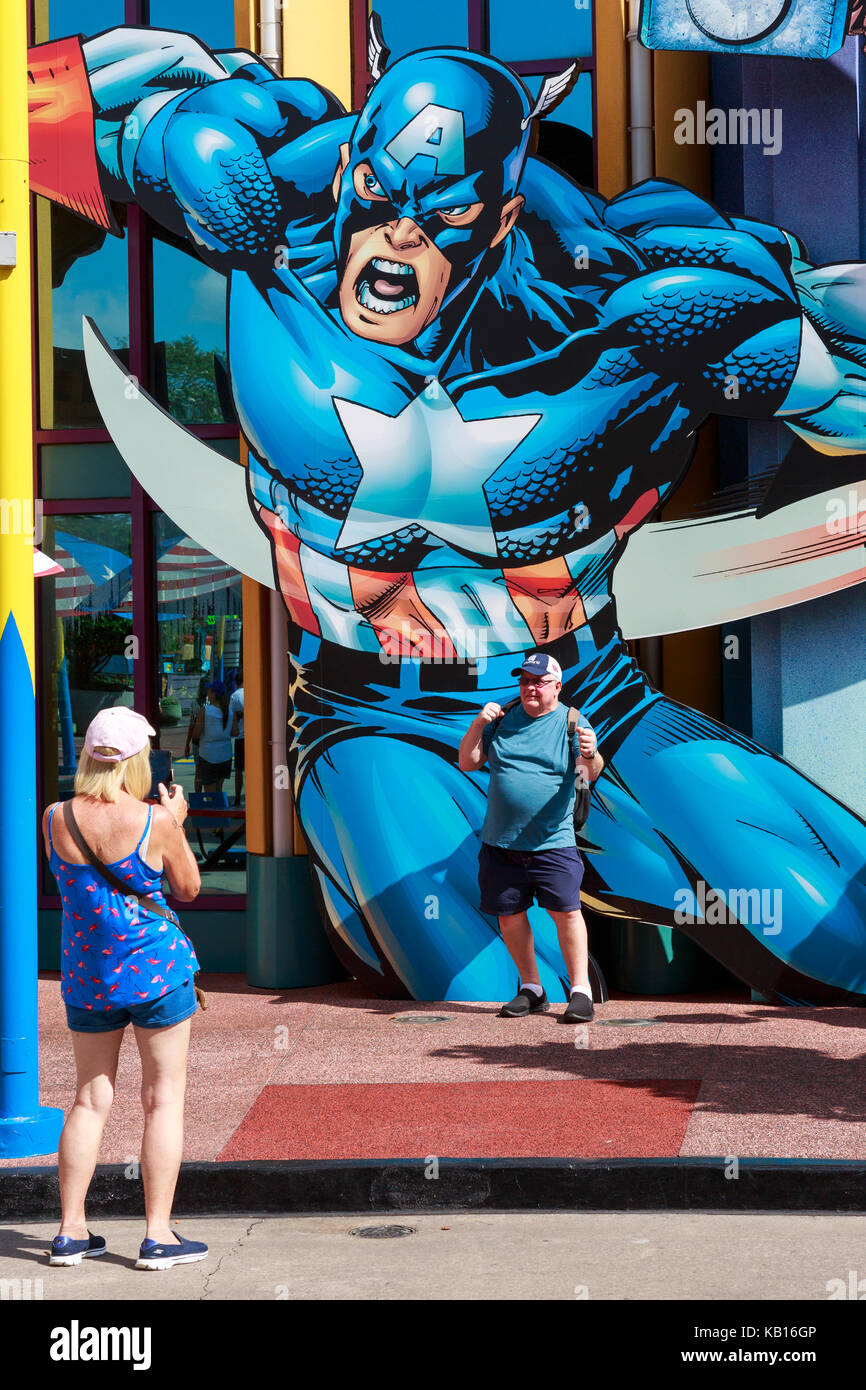 Avoir son tourisme photo prise alors qu'il pose à une affiche de Captain America, Universal Studios, Orlando, Floride, USA Banque D'Images