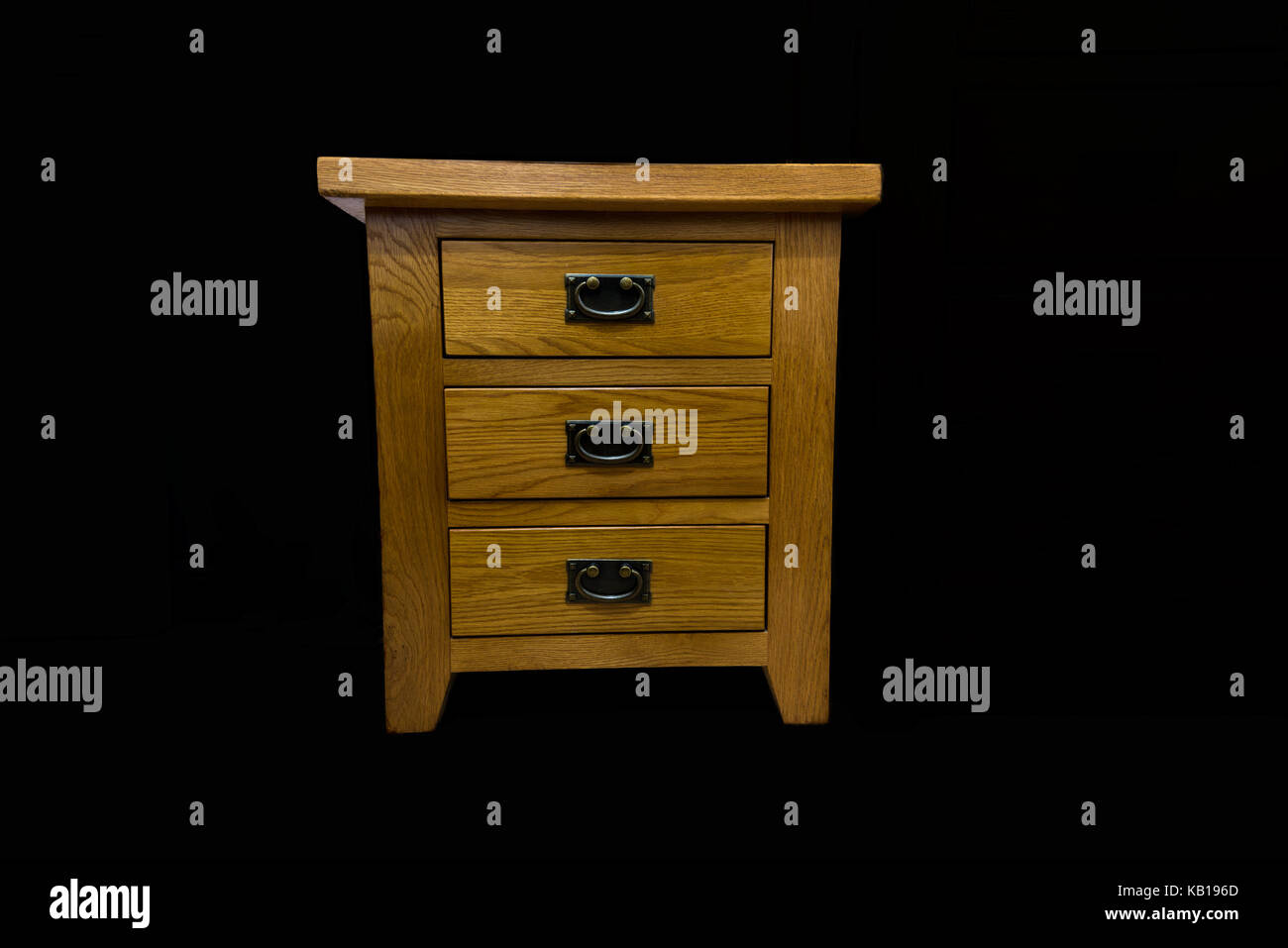 Un ensemble de traités antiques tiroirs chêne isolé sur un fond noir avec poignées smiley Banque D'Images