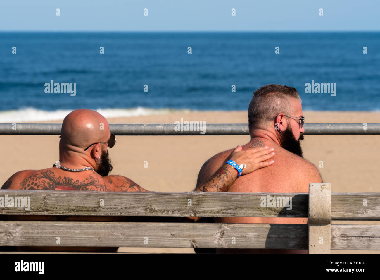 Asbury Park, NJ USA -- 10 septembre 2017 -- deux hommes portant la barbe et les lunettes de soleil sont assis sur un banc sur la promenade d'Asbury Park avec l'océan en Banque D'Images