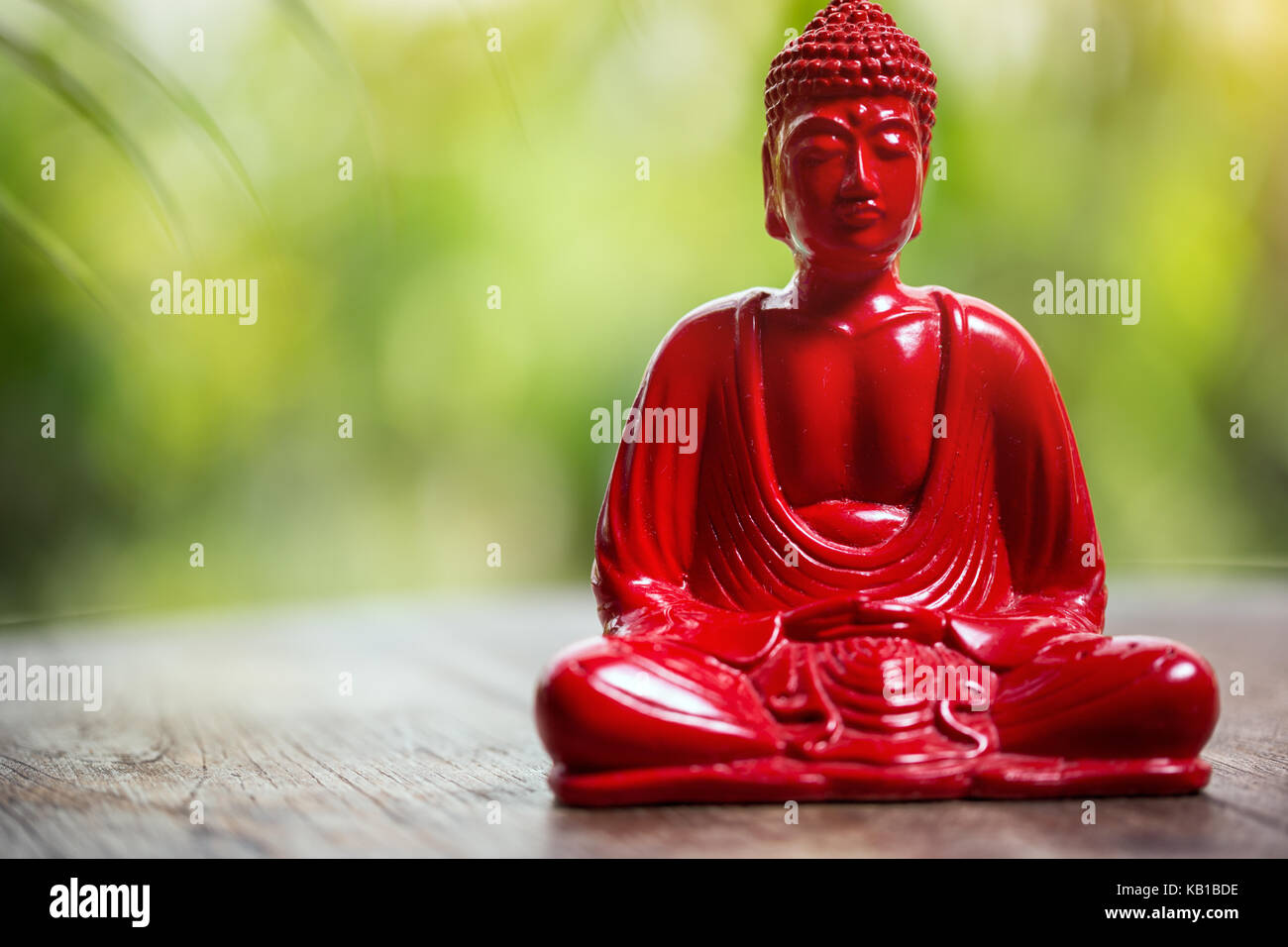 La figure de bouddha rouge sur fond vert Banque D'Images
