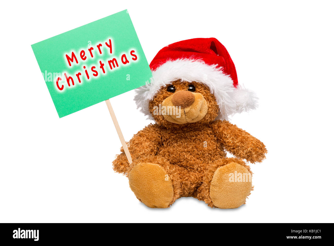 Un ours en peluche portant un chapeau de Père Noël avec un panneau avec Joyeux Noël écrit dessus, isolé sur un fond blanc. Banque D'Images