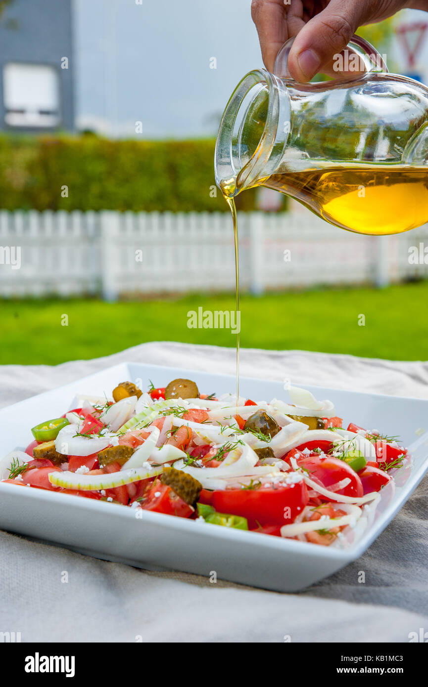 Maison, salade saine avec les tomates, l'oignon et l'huile d'olive Banque D'Images