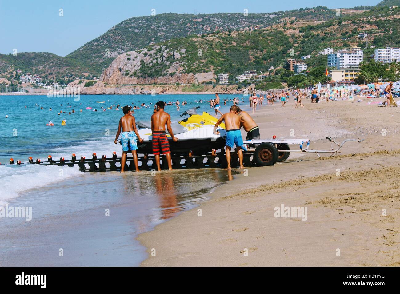 Un groupe d'employés de la water sports centre descend le jet ski sur l'eau à l'aide d'un dispositif spécial. Banque D'Images