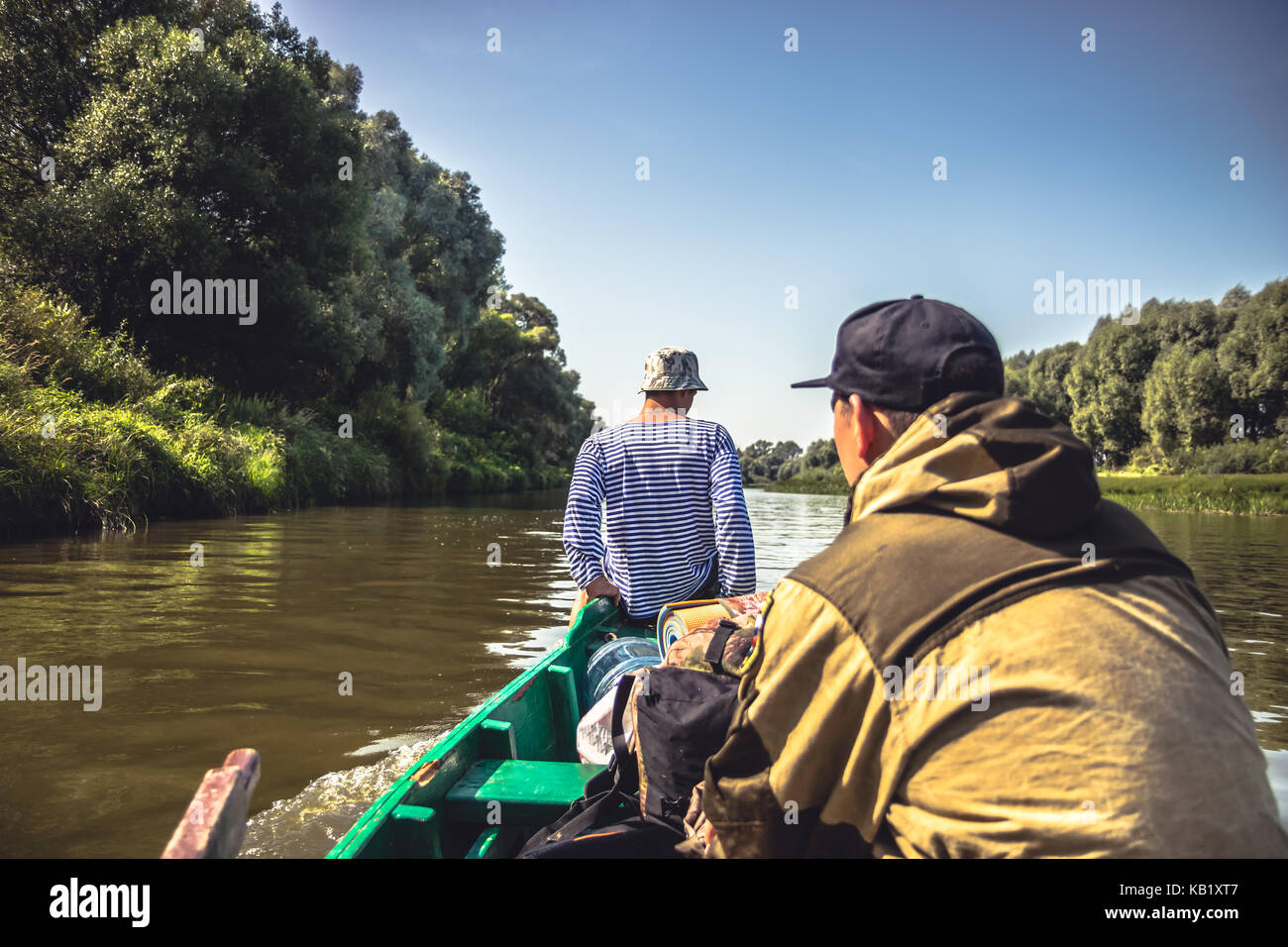 Les hommes de la voile sur le bateau à moteur par la rivière vers le camp de chasse pendant la saison de la chasse Banque D'Images