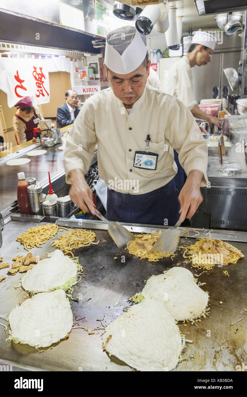 Le Japon, Kyushu, Hiroshima, restaurant, cuire en préparation d'okonomiyaki, Banque D'Images