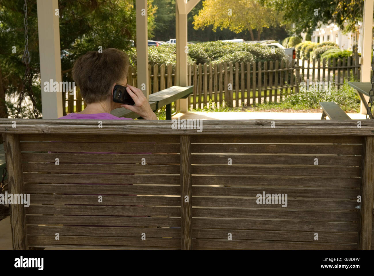 Senior woman swinging et parler sur téléphone cellulaire au complexe, USA Banque D'Images