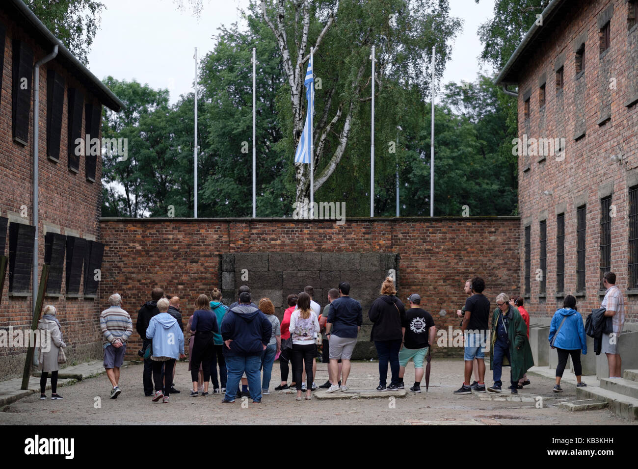 Les touristes à la recherche à un mur utilisé pour un peloton d'exécutions à l'Auschwitz camp de concentration Nazi, Pologne Banque D'Images