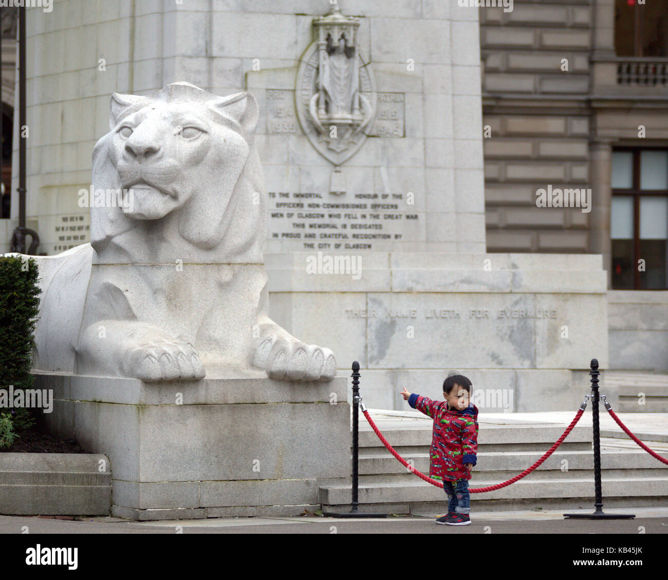Jeune garçon enfant chinois pointant touristiques george square george square Glasgow lion cénotaphe Banque D'Images