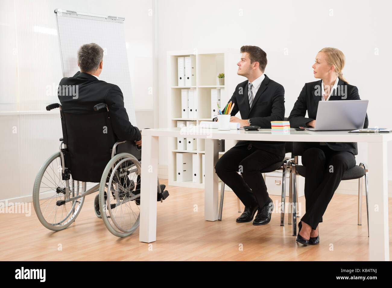 Mature businessman handicapés expliquant à ses collègues de bureau Banque D'Images