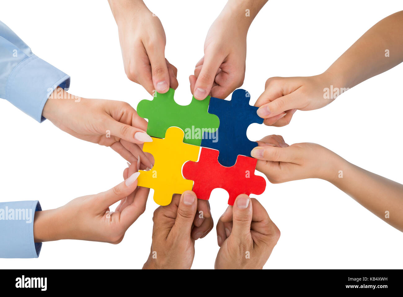 Close-up de personnes Hands Holding Jigsaw Pieces sur fond blanc Banque D'Images