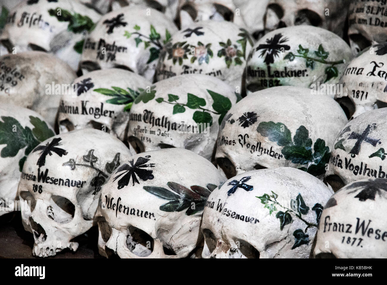 Peint avec des crânes, des noms de fleurs colorées et de croix dans le  charnier ou beinhaus, Hallstatt, Autriche Photo Stock - Alamy