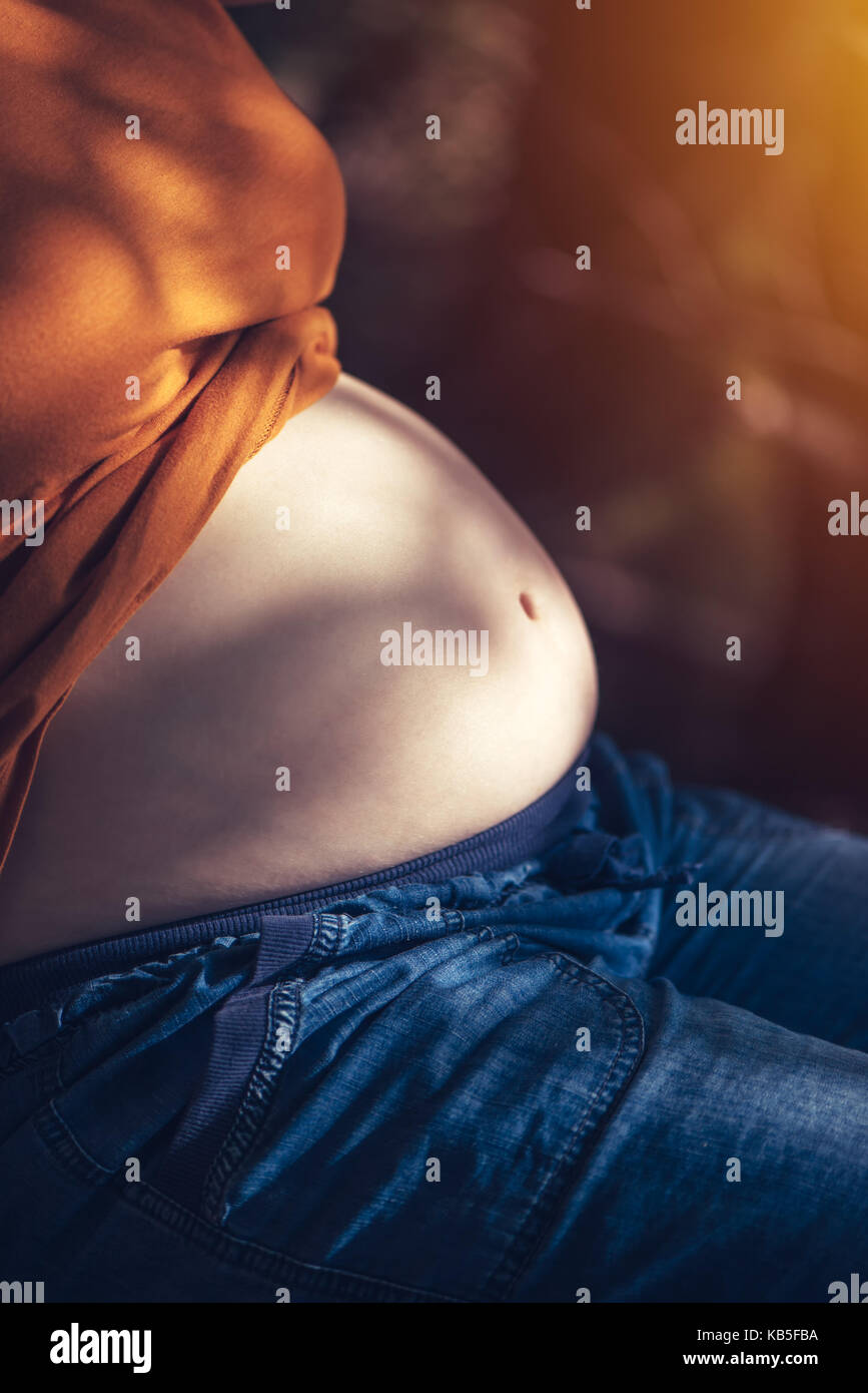 Femme enceinte se détendre et bronzer sur le ventre du soleil d'été chaude, selective focus Banque D'Images
