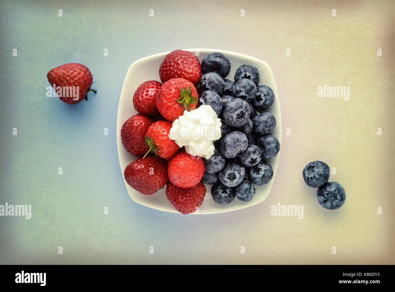 Les fraises et les bleuets dans un bol blanc avec incrustation de texture Banque D'Images