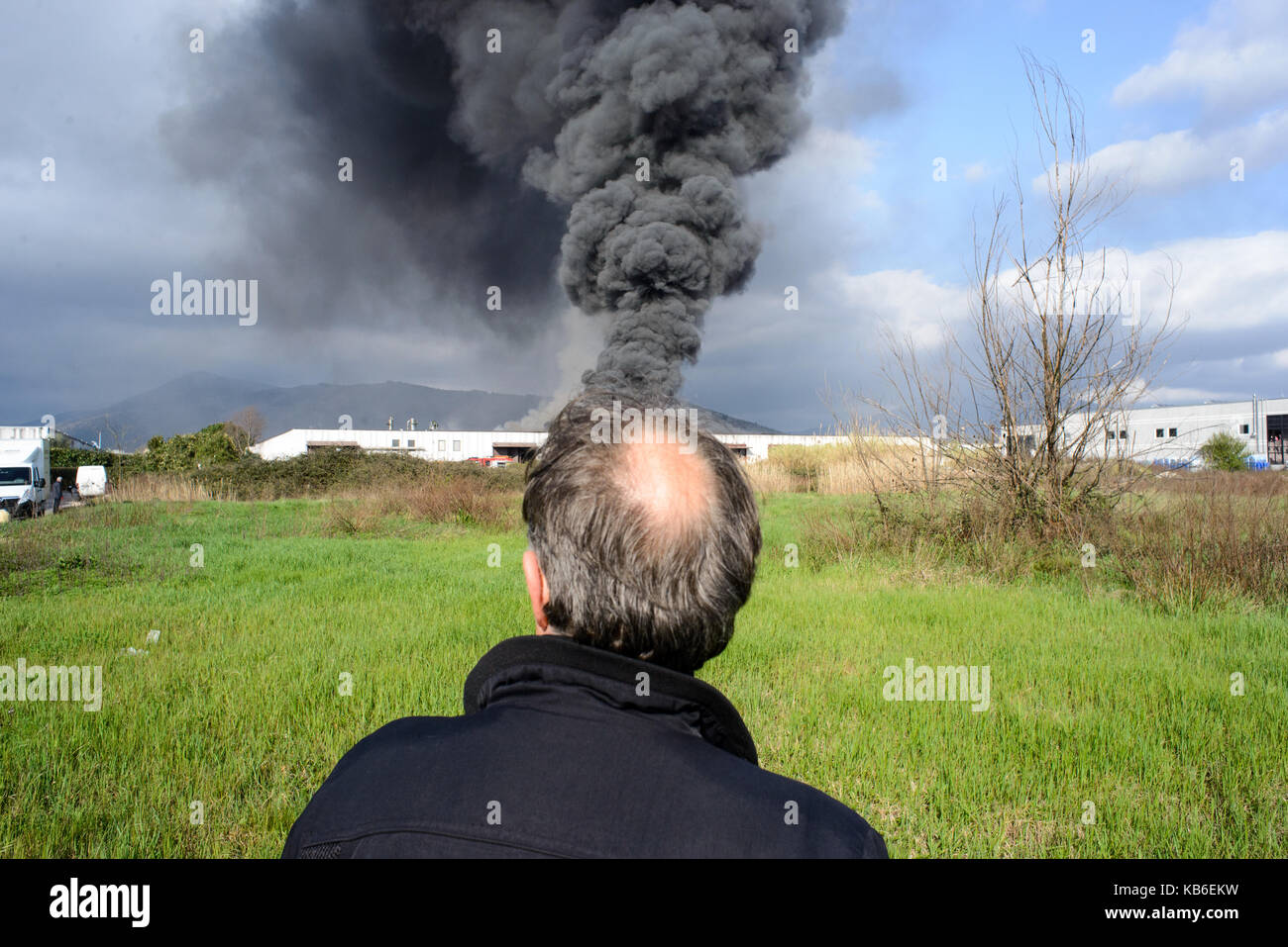 Un homme âgé vu de derrière avec un nuage de fumée sur l'arrière-plan qui sort de sa tête, prato italie Banque D'Images