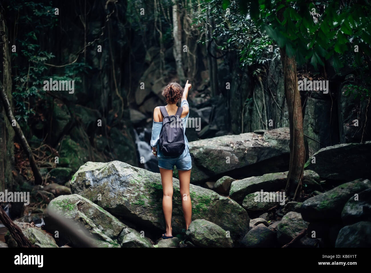 Vue arrière de jeune femme avec sac à dos dans la jungle tropicale et dirigés à l'écart Banque D'Images
