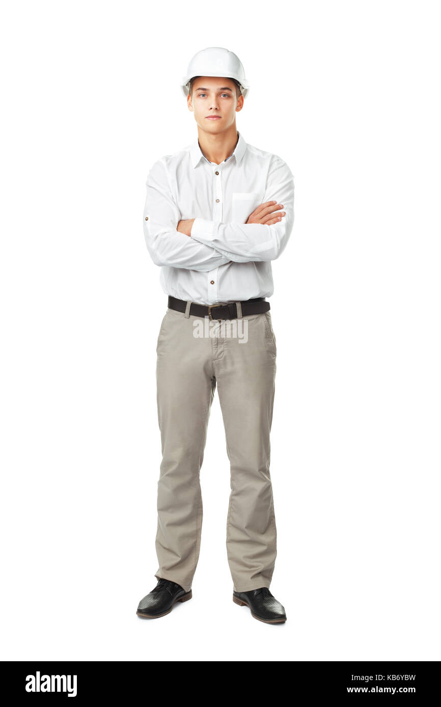 Portrait de jeune ingénieur portant un casque blanc debout avec les mains pliées contre isolé sur fond blanc Banque D'Images