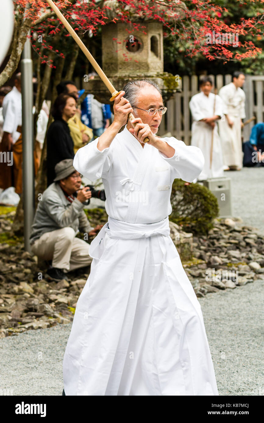 Maître japonais samurai, homme mûr, habillé en blanc avec formation, bokken ou bokuto, épée samouraï, Tada en lieu de culte. Festival de Genji. Banque D'Images