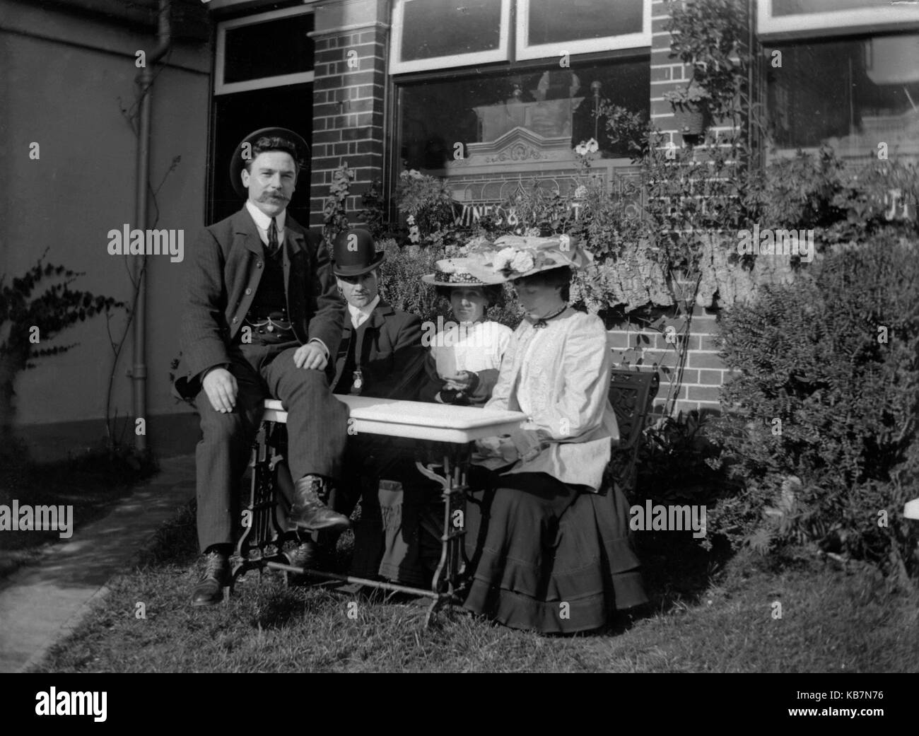 AJAXNETPHOTO. 1903. FINCHAM, Angleterre. - Vins et spiritueux - Deux hommes bien habillés avec MESDAMES POSENT POUR LA CAMÉRA DANS LE JARDIN D'UNE MAISON PUBLIQUE. Photographe:Inconnu © COPYRIGHT DE L'IMAGE NUMÉRIQUE PHOTO VINTAGE AJAX AJAX BIBLIOTHÈQUE SOURCE : VINTAGE PHOTO LIBRARY COLLECTION REF:AVL 1173 Banque D'Images