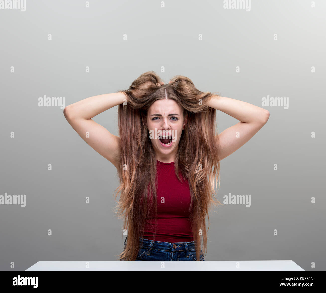 Les jeunes ont souligné femme avec ses mains dans ses cheveux portrait, concept de la peur, la panique, de la rage et le stress Banque D'Images