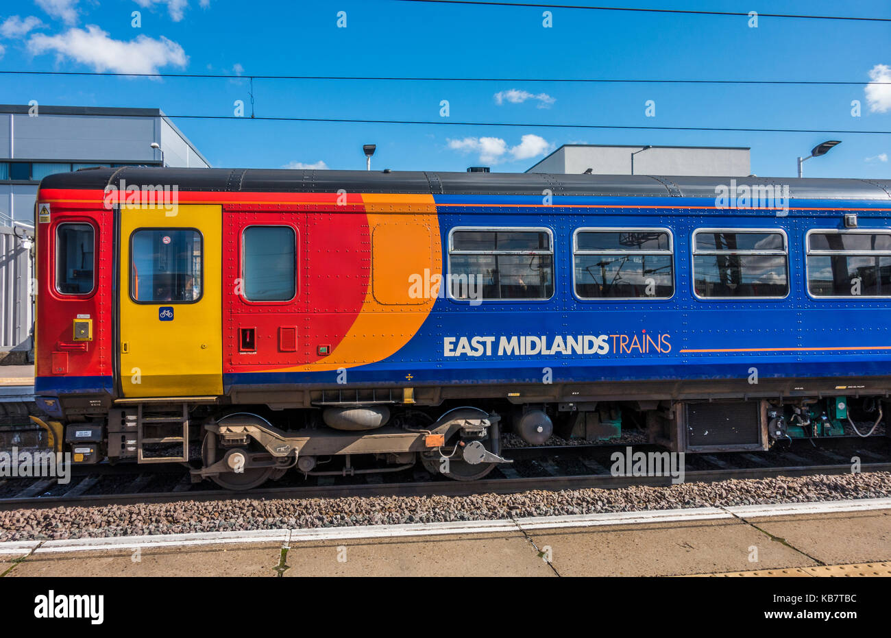 Un East Midlands trains, train, contre un ciel bleu ensoleillé, à une plate-forme à la gare de Peterborough, Cambridgeshire, Angleterre, Royaume-Uni. Banque D'Images