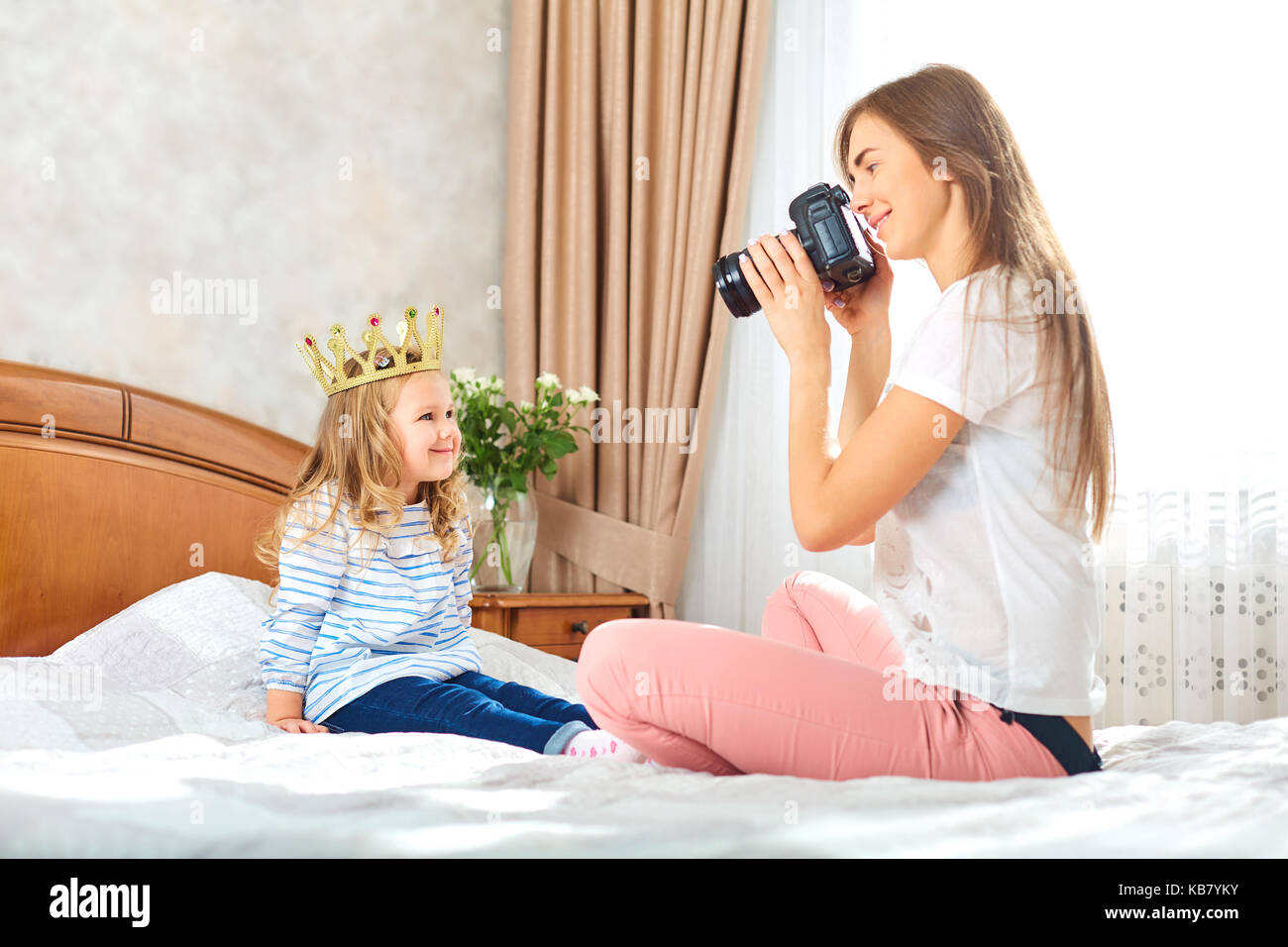 Maman prend des photos de son enfant dans une chambre . Banque D'Images