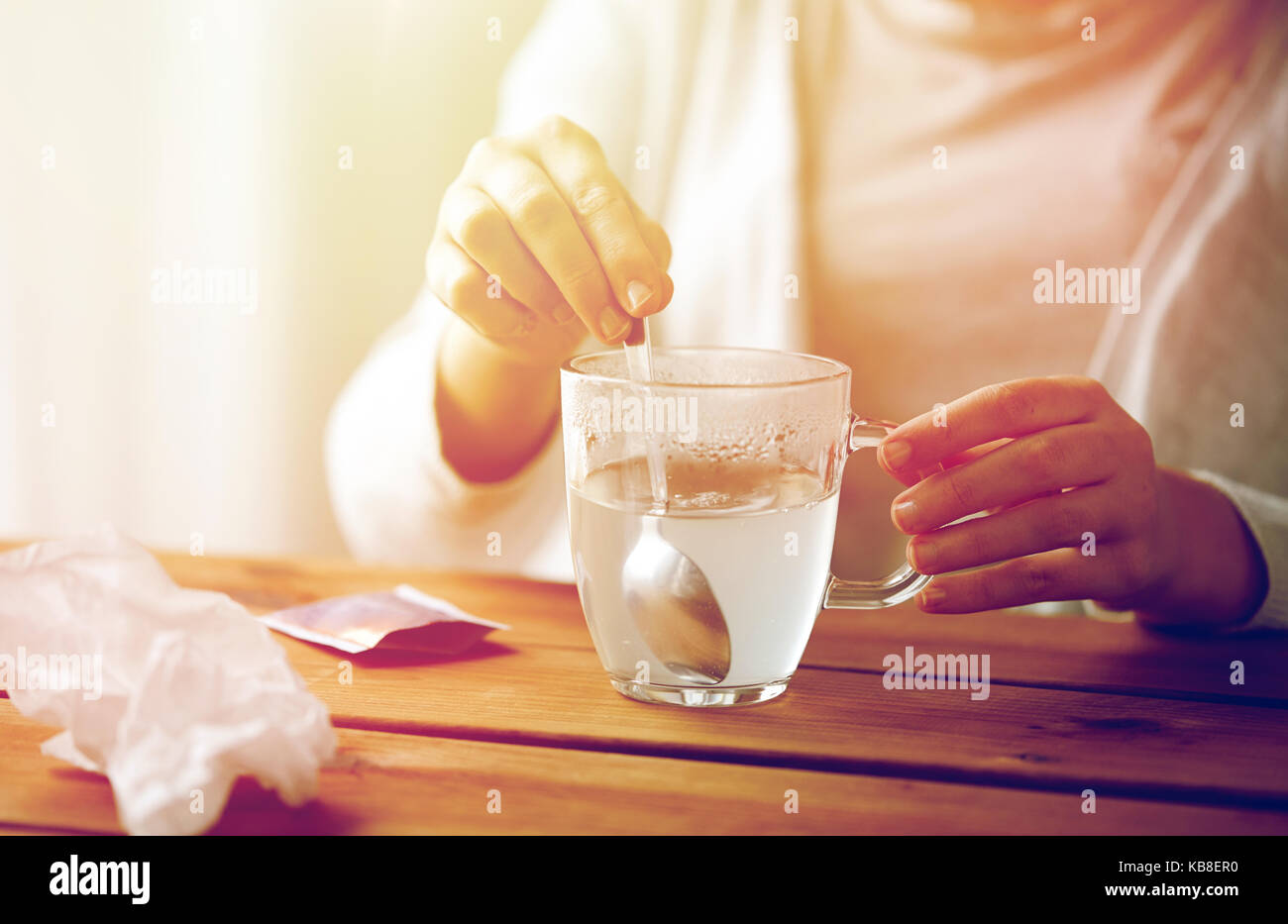 Femme en remuant de médicament en tasse avec cuillère Banque D'Images