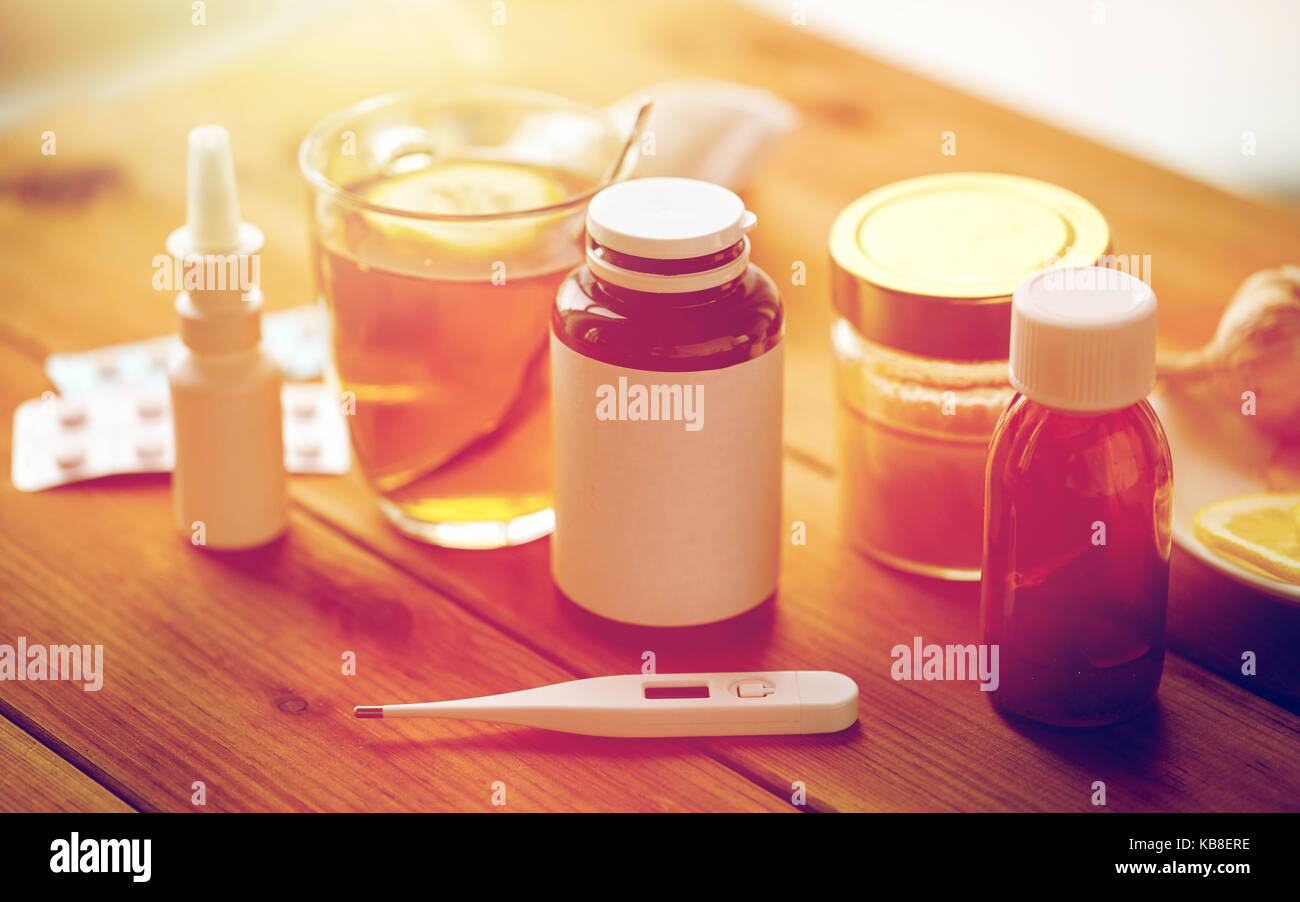 La drogue, thermomètre, le miel et une tasse de thé sur bois Banque D'Images