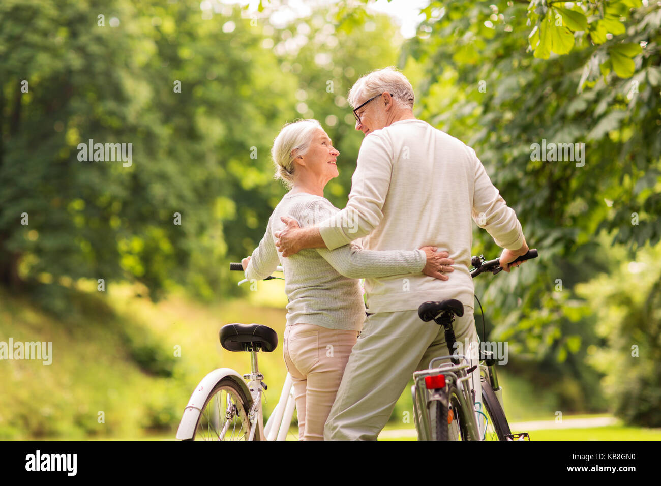 Happy senior couple with bicycles at summer park Banque D'Images