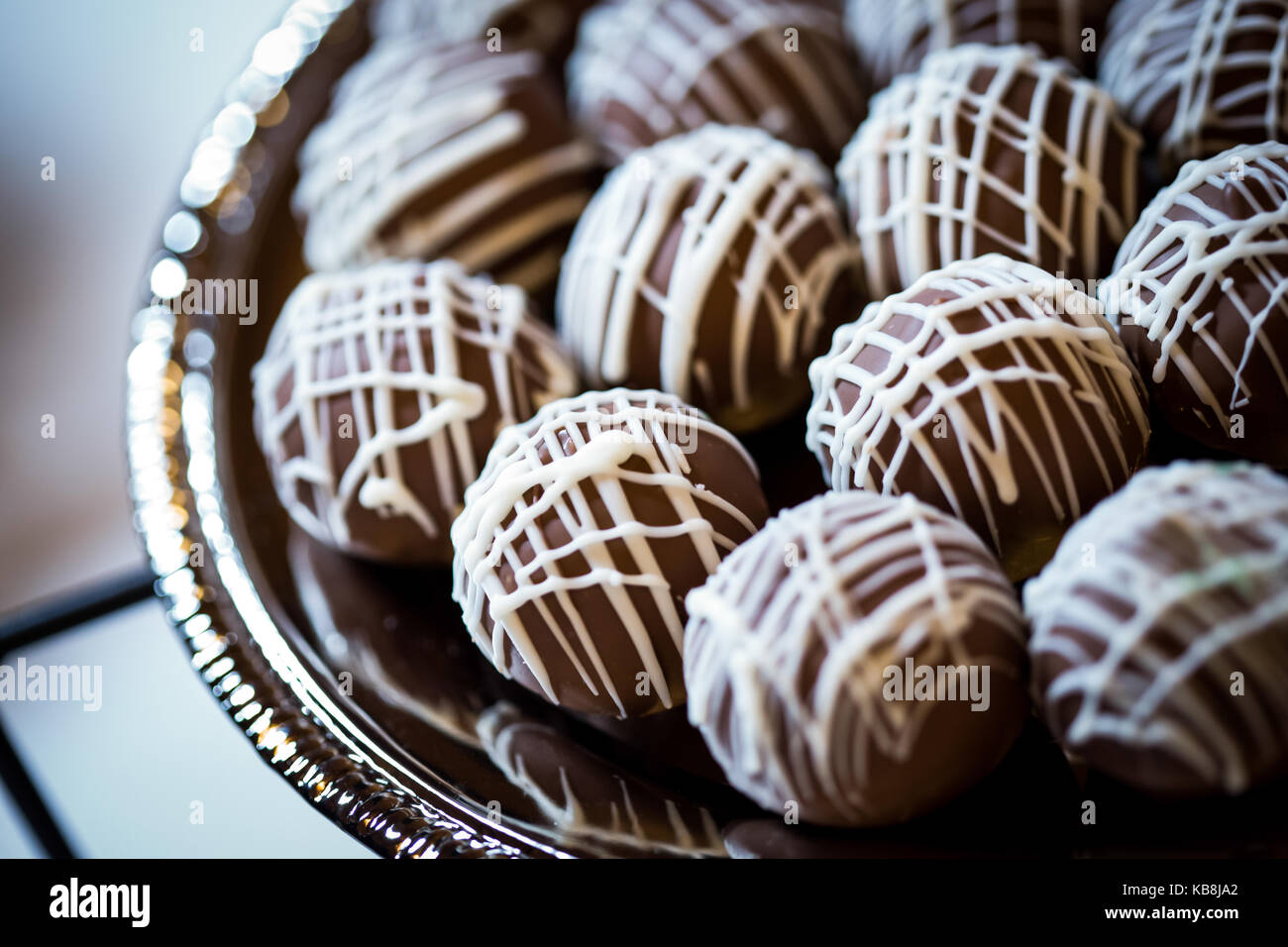 Gâteau au chocolat et crème à la vanille recouvert de boules de glace sur un plateau d'argent. Banque D'Images