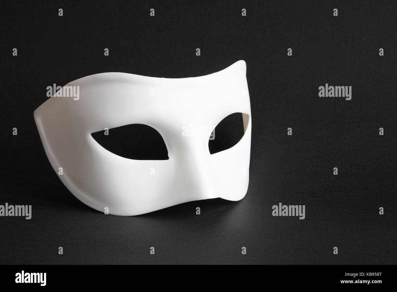 Masque de Venise blanc couché sur fond noir Banque D'Images