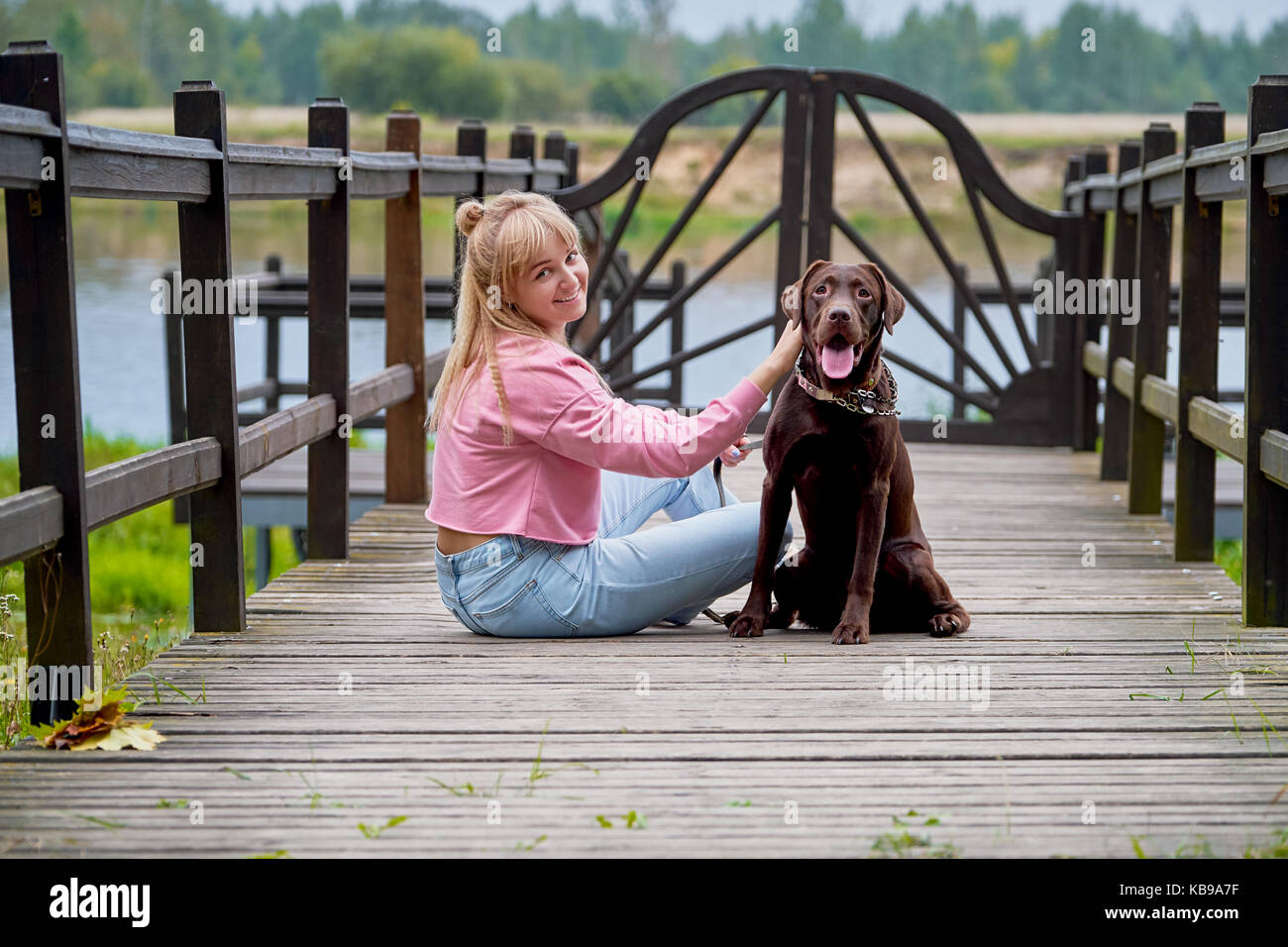 Smiling girl relaxing with dog Banque D'Images