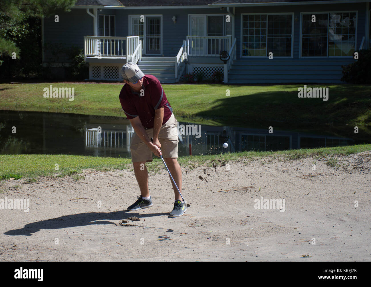 Un golfeur de frapper une balle dans une fosse de sable Banque D'Images