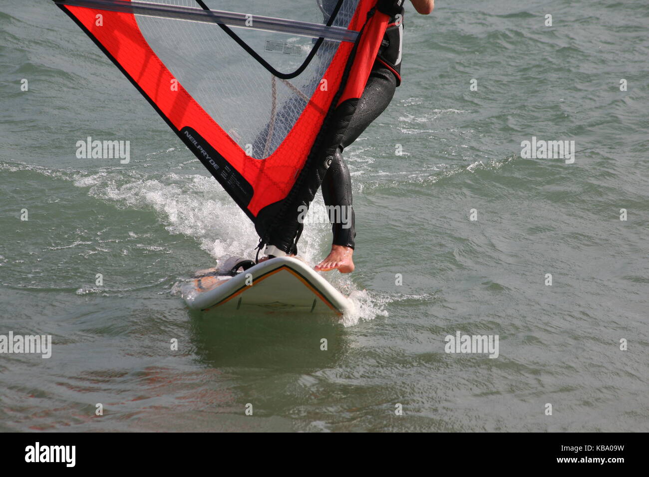 Surfer sur une planche de surf avec la voile --- surf surfeur auf mit Segel Banque D'Images