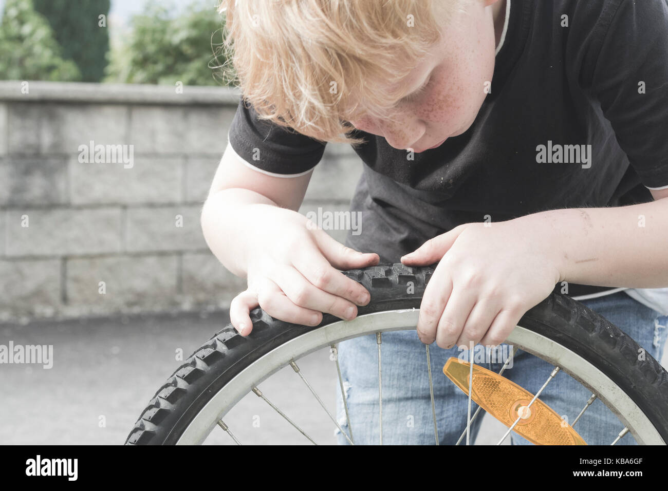 Un garçon est réparer son vélo Banque D'Images