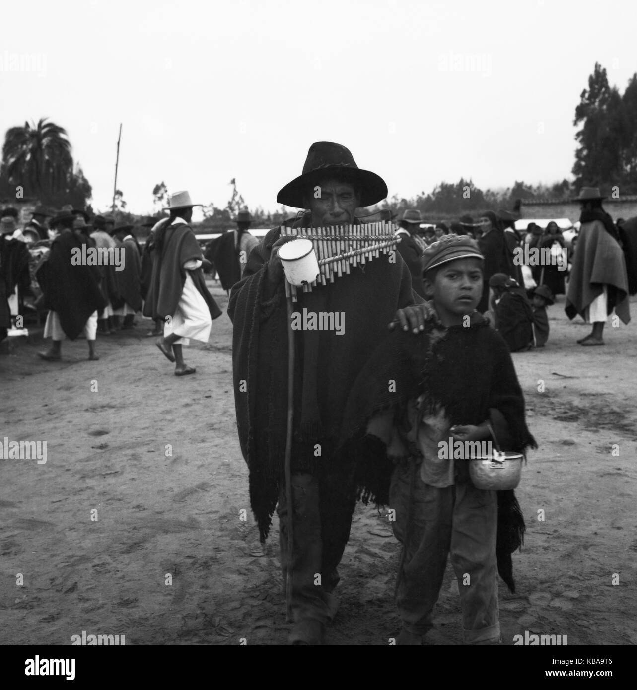 Un Panflötenspieler verdient seinen Lebensunterhalt in einer Straße dans der Stadt Otavolo, Équateur 1960 er Jahre. Pan flute player dans une rue de la ville de Otavolo, Équateur 1960 er Jahre. Banque D'Images