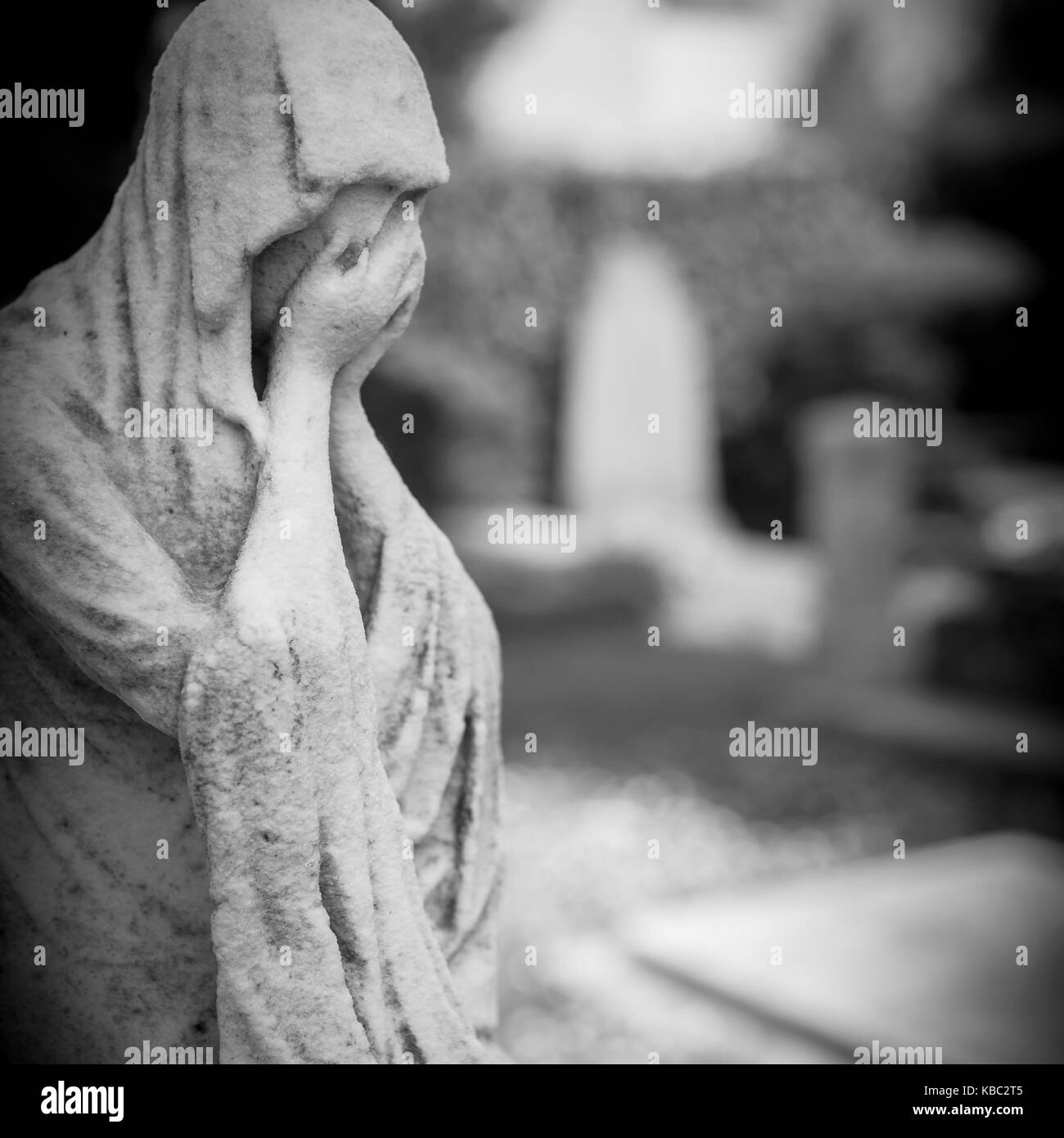 Ancienne statue de femme pleurer dans ses mains. arrière-plan flou flou artistique. Banque D'Images