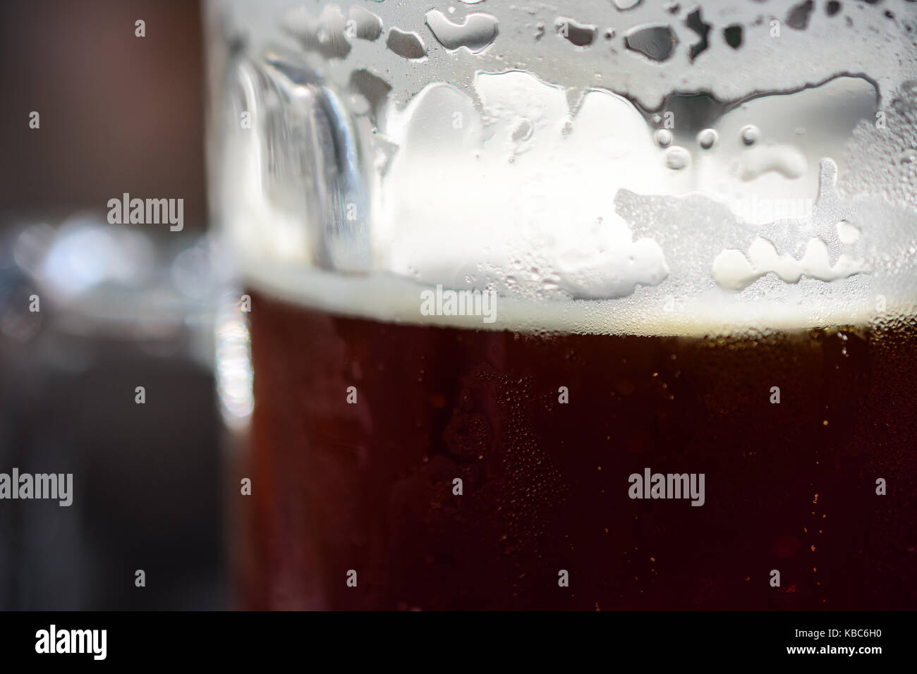 Close-up de boisson fraîche pinte de bière bière noire avec condensation, mousse écumeuse et bulles prêt à boire Banque D'Images