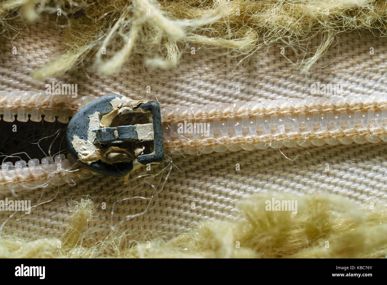 Close-up of old zipper entouré de fibres dans motif vert olive Banque D'Images
