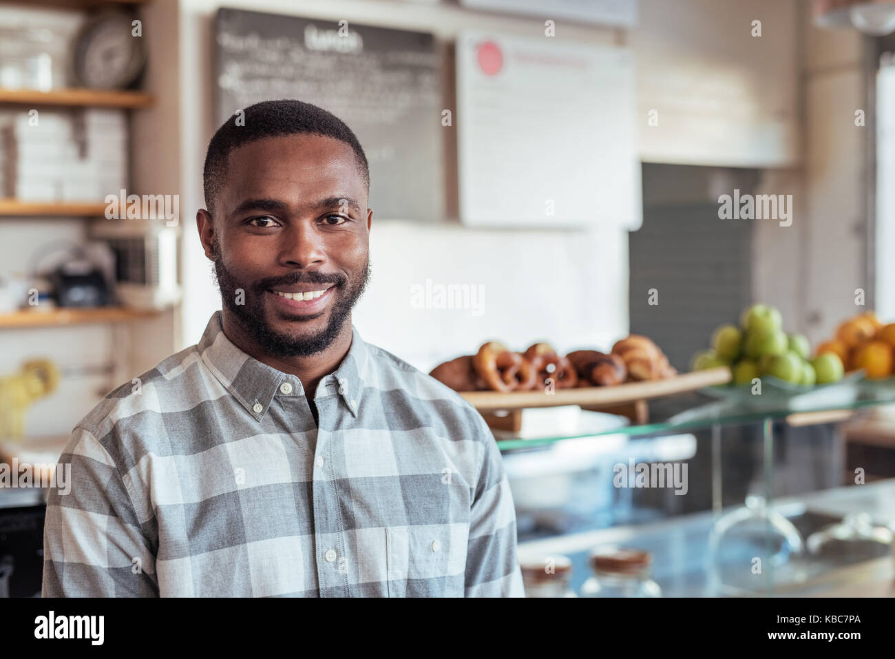 Jeune entrepreneur de l'Afrique debout dans son cafe Banque D'Images