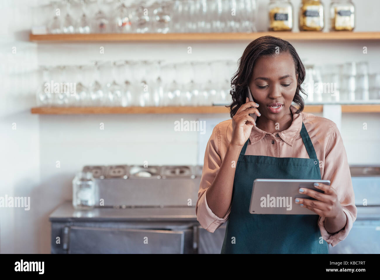 Souriante jeune entrepreneur africain travaillant dans son café Banque D'Images